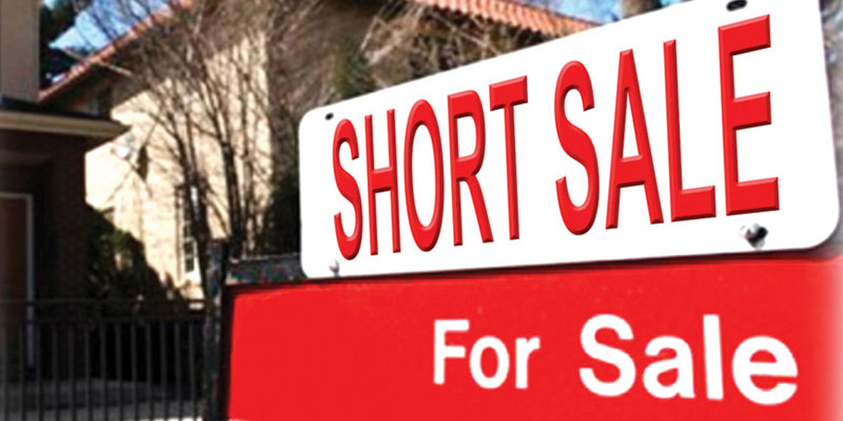 Short sale real estate sign with home in background